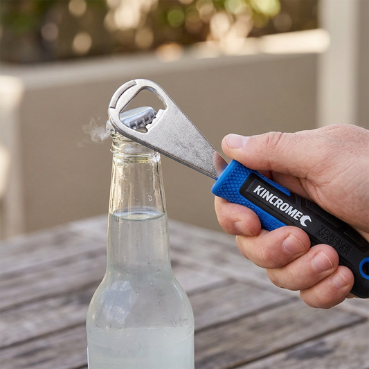 KINCROME TorqueMaster bottle opener lifting a cap from a glass bottle